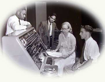 Admiral Grace Hopper, USN, with three other programmers at the control panel of the UNIVAC I computer.