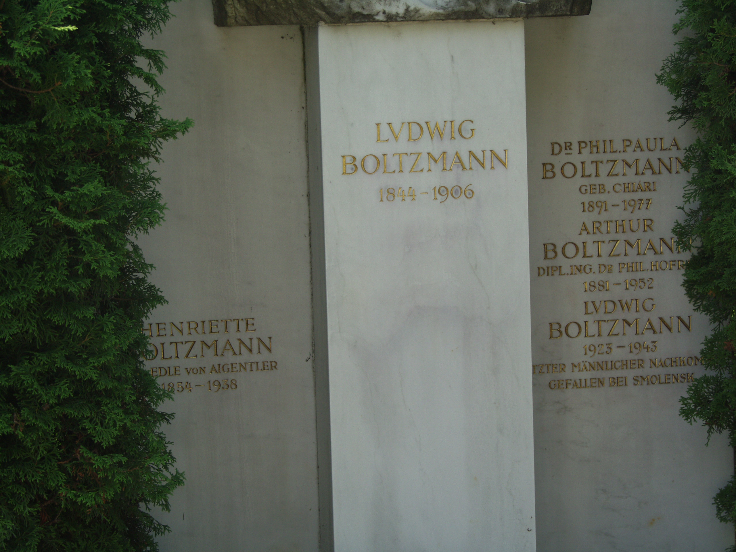 
Vienna, Austria.
Boltzmann's Tomb in the Zentralfriedhof (Central Cemetary).
The Tomb is in Gruppe 14 C Grab No 1 (groupe 14 grave number 1).
Photos by
Tom Schneider or of him by Gerd Muller.
2002 July 14.
This image:
Stone carving below Boltzmann's bust
in three vertical sections:
1. HENRIETTE BOLTZMANN
(lost)EDLE von AIGENTLER
1854-1938
2. LVDWIG BOLTZMANN 1844-1906.
3. Dr PHIL.PAULA
BOLTZMANN
GEB. CHIARI
1891-1977
ARTHUR
BOLTZMANN
DIPL.ING.Dr PHIL. HOFR(lost)
1881-1952
LVDWIG
BOLTZMANN
1923-1943
(lost)TZTER MANNLICHER NACHKOM(lost)
GEFALLEN BEI SMOLENSK.
(a href =
