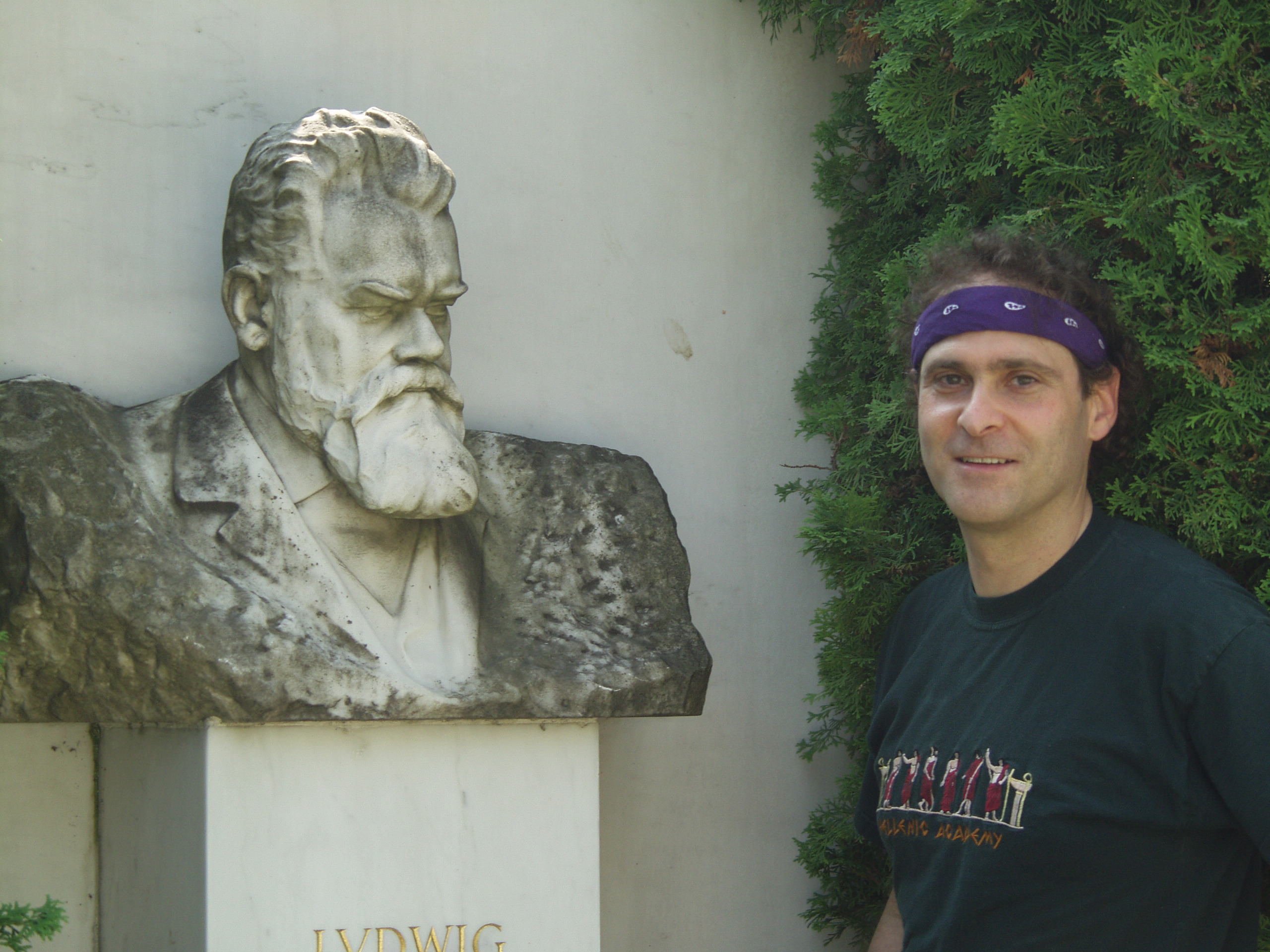 Vienna, Austria. Boltzmann's Tomb in the Zentralfriedhof (Central Cemetary). The Tomb is in Gruppe 14 C Grab No 1 (group 14 grave number 1). Photos by Tom Schneider or of him by Gerd Muller. 2002 July 14. This image: Tom Schneider with bust of Boltzmann. <a href = 